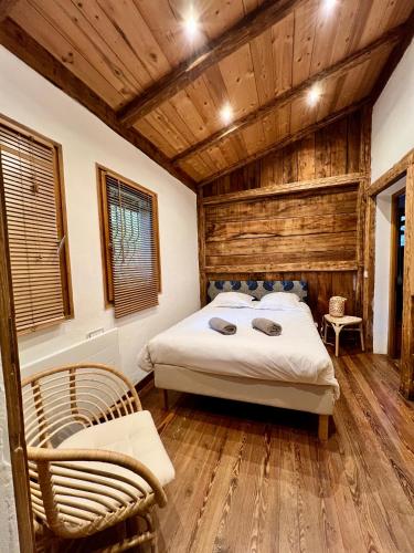 une chambre avec un lit et un plafond en bois dans l'établissement Chalet Mao, à Megève