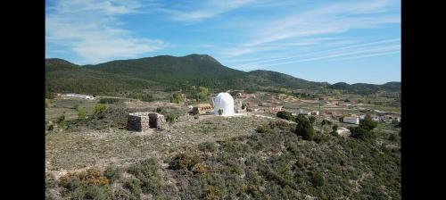 a white observatory on a hill with mountains in the background at Casa la Cisterna in Pina de Montolgrao