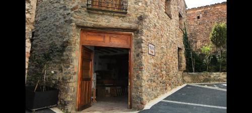 a stone building with a large wooden door at Casa la Cisterna in Pina de Montolgrao