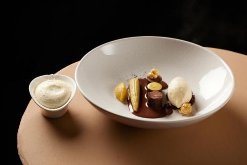 a bowl of chocolate and ice cream on a table at LA CHENEAUDIÈRE - Hôtel Spa - Relais & Châteaux - Restaurant étoilé in Colroy-la-Roche