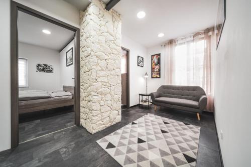 un salon avec un canapé et un mur en pierre dans l'établissement Loft moderne en Alsace! Proche Europa Park, à Hilsenheim