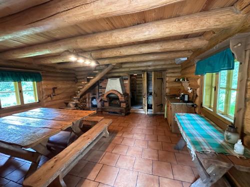 a dining room with a large wooden table and a fireplace at Koplimadise Palkmaja in Maeru