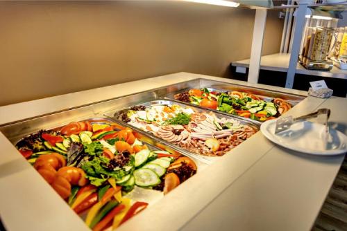 a buffet with several trays of different types of food at Mercure Kyiv Congress in Kyiv