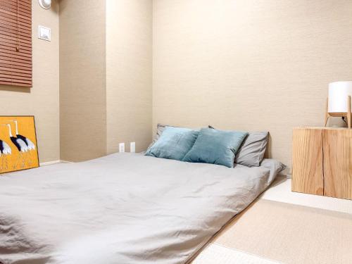 a bedroom with a large white bed with blue pillows at Triphome Tokyo Sugamo 2024 New 3 mins 2 stations in Tokyo