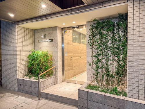 a lobby with a door with a green wall at Triphome Tokyo Sugamo 2024 New 3 mins 2 stations in Tokyo