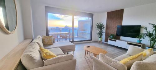 ein Wohnzimmer mit zwei Sofas und einem Flachbildfernseher in der Unterkunft PREMIUM Magníficas Vistas Panorámicas con Terraza - By Aloha Palma in Águilas