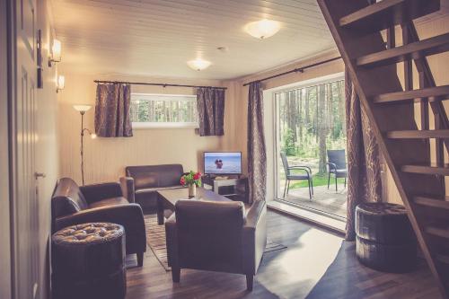 una sala de estar con muebles y una escalera con patio. en Vanaõue Holiday Home en Kalana