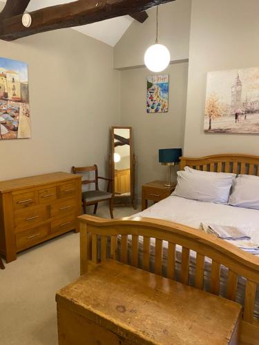 Un dormitorio con una cama, una silla y un espejo. en Kezbah 1, 22 the square centre of Dalston village, en Carlisle