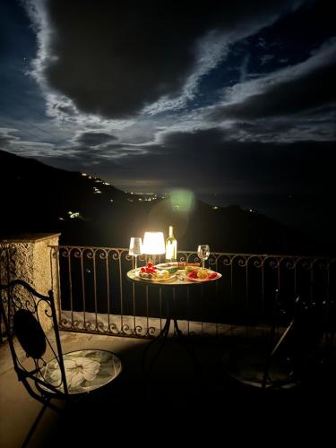 a table with a plate of food on a balcony at night at La quiete accesa in Vernazza