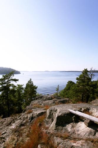 a bench sitting on top of a mountain overlooking the water at Idöborgs Stuguthyrning in Nämdö