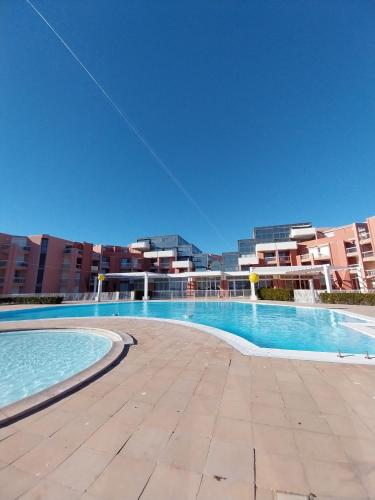 Un cerf-volant survole une grande piscine. dans l'établissement CAP CORNICHE studio avec espace nuit, à Sète