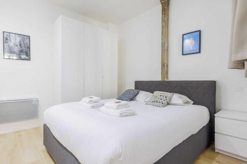 une chambre avec un lit blanc avec des serviettes dessus dans l'établissement Loft d'Exception pour 6 Personnes - Voltaire 11e, à Paris