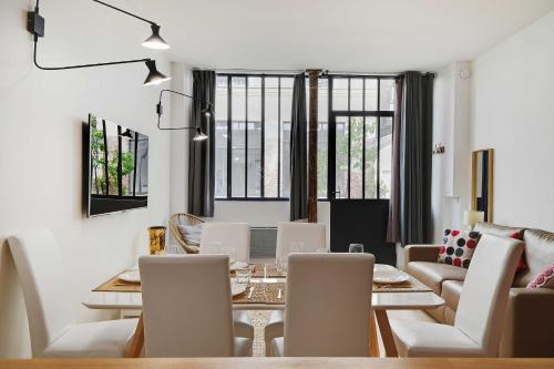une salle à manger et un salon avec une table et des chaises dans l'établissement Loft d'Exception pour 6 Personnes - Voltaire 11e, à Paris