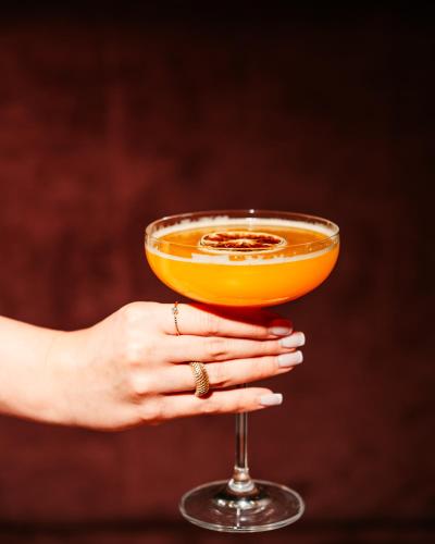 a woman holding a glass of orange drink at Arche Nałęczów & SPA dawne Sanatorium Milicyjne in Nałęczów