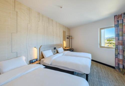 a hotel room with two beds and a window at B&B HOTEL Nice Stade Riviera in Nice