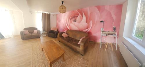 a living room with a couch and a pink wall at l'atypique des fouleries in Châteaudun