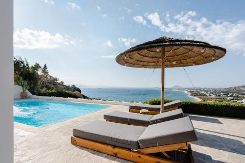 a pair of chairs and an umbrella next to a swimming pool at Agapui-Peaceful Retreat with Amazing Views in Naxos Chora