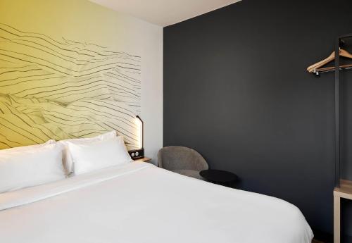 a bedroom with a bed and a painting on the wall at B&B HOTEL Bois d'Arcy Saint Quentin en Yvelines in Bois-dʼArcy