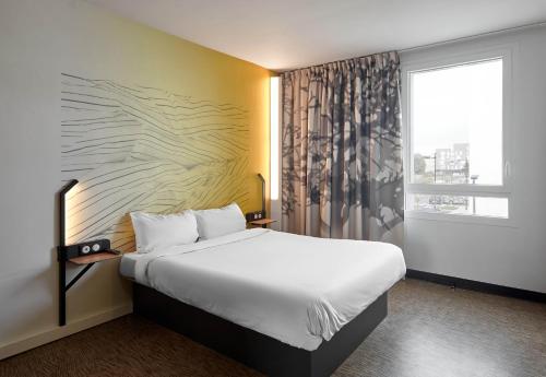 a hotel room with a large bed and a window at B&B HOTEL Bois d'Arcy Saint Quentin en Yvelines in Bois-dʼArcy