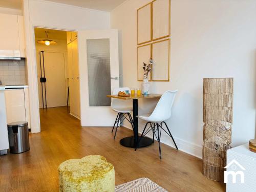 une cuisine avec une table et des chaises dans une pièce dans l'établissement St Honore Champs Elysees by Melvane, à Paris