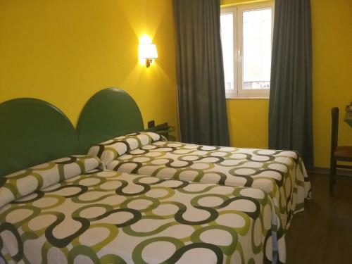 a bedroom with a bed in a yellow room at Hotel VillaPaloma in La Virgen del Camino