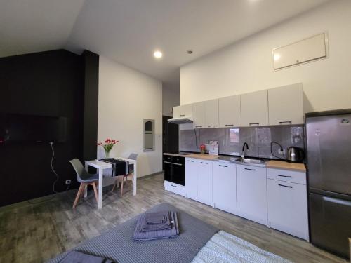 クフィジンにあるApartamenty Parkowe nr 9の白いキャビネットとテーブル付きの広いキッチン