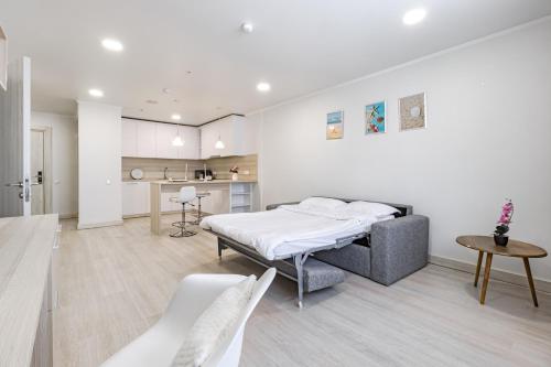 a bedroom with a bed and a kitchen at Y'estoria апарт-отель, район EXPO центра in Astana