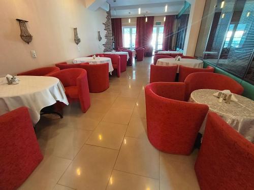 Villa Bella Casa في ووميانكي: غرفة طعام مع طاولات وكراسي حمراء