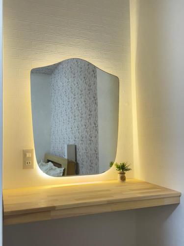 a mirror on a shelf in a room at 晶 距离车站步行5分钟 关西机场难波心斋桥直达 5 bedroom最多可住13人 超大客厅大电视有Netflix in Osaka