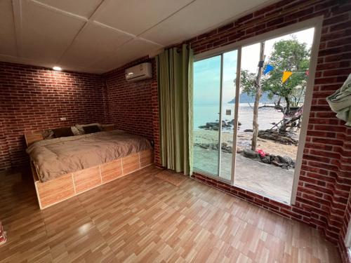 a bedroom with a bed and a large window at Rasta view Bangalows in Ko Chang