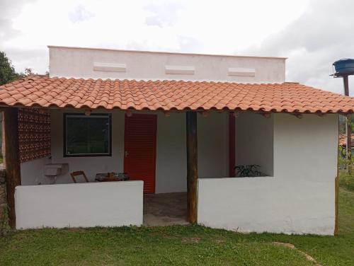 a small white house with a red roof at Pouso do Elefante in Serra do Cipo