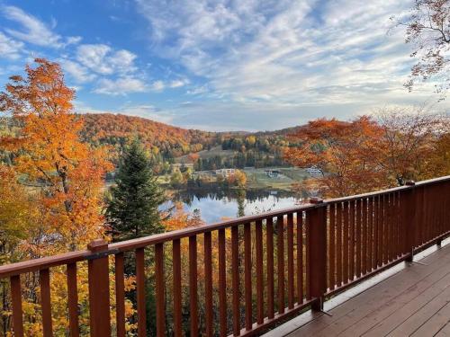 a view of a lake from a wooden deck at Le Tranquille in Mont-Blanc