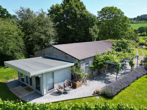 a small shed in the middle of a garden at Vineyard lodge in Herefordshire in Ledbury