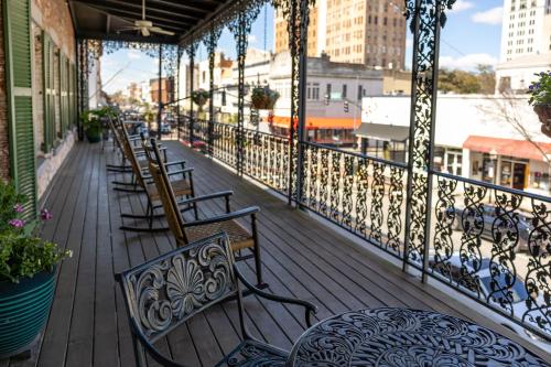 a balcony with chairs and tables on a building at The Marshall House, Historic Inns of Savannah Collection in Savannah