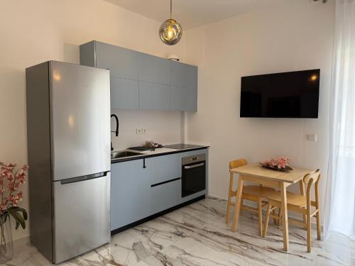 a kitchen with a stainless steel refrigerator and a table at Madi Luxury Stay Patra in Patra