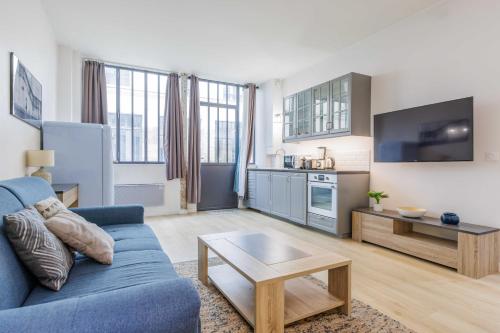 un salon avec un canapé bleu et une table dans l'établissement Loft Moderne et Spacieux - 6 Couchages Voltaire 11, à Paris
