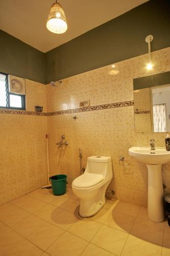 a bathroom with a toilet and a sink at Cliff and Coral Varkala, North Cliff in Varkala
