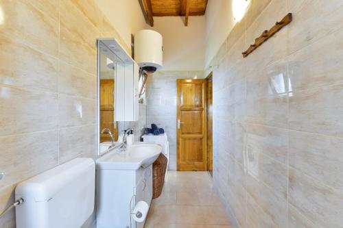 a bathroom with a white sink and a mirror at Villa Serena with pool in Budak