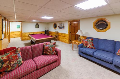 a living room with two couches and a pool table at Log Retreat at Fish Creek by Simple Life Rentals in Fish Creek