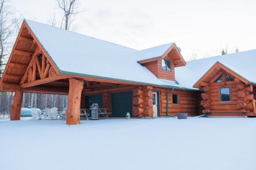 a log cabin with a snow covered roof at Log Retreat at Fish Creek by Simple Life Rentals in Fish Creek