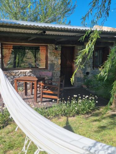 a hammock in front of a cottage at Estancia Altos del Durazno in Estancia Grande
