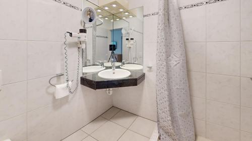 a bathroom with two sinks and a mirror at Gartenwohnung, nahe Zentrum Zürich und Flughafen in Wallisellen