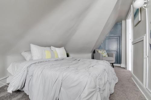 una camera da letto bianca con un letto bianco e una sedia di G6 central location museums FREE PARKING a Richmond