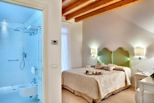 1 Schlafzimmer mit einem großen Bett und einem Badezimmer in der Unterkunft Agriturismo Ca' Beatrice - Venice Airport in Favaro Veneto