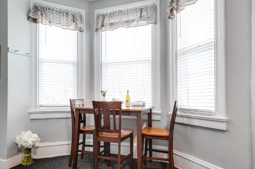 a dining room with a table and chairs and windows at G5 KING BED central location museums FREE PARKING in Richmond