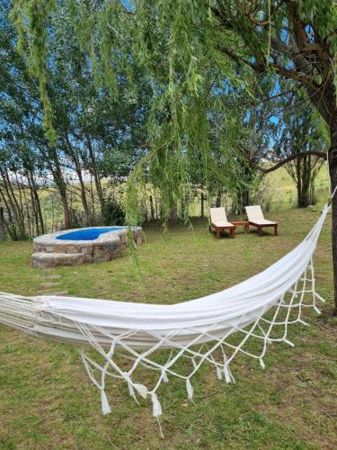 a white hammock hanging from a tree in a yard at Estancia Altos del Durazno in Estancia Grande