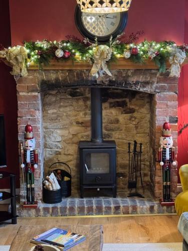 a stone fireplace with a clock on top of it at Bay House in Broadway