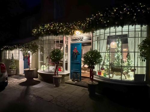 a christmas store front with christmas lights and trees at Bay House in Broadway