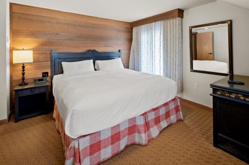 a bedroom with a large bed and a mirror at von Trapp Family Lodge & Resort in Stowe