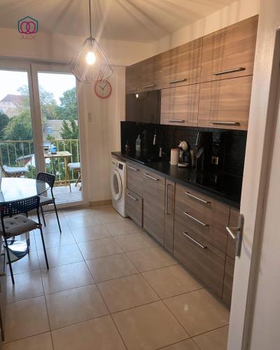 une cuisine avec des appareils en acier inoxydable et une salle à manger dans l'établissement L'Exclusif - Strasbourg, à Strasbourg